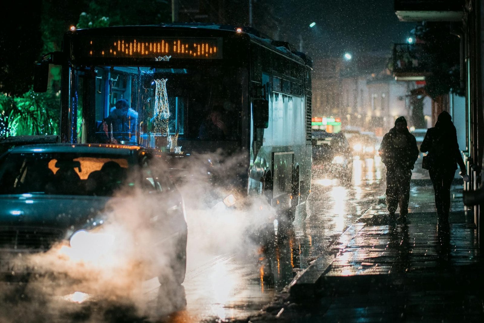 People Walking on the Street at Night next to a Bus, Kutaisi, Georgia